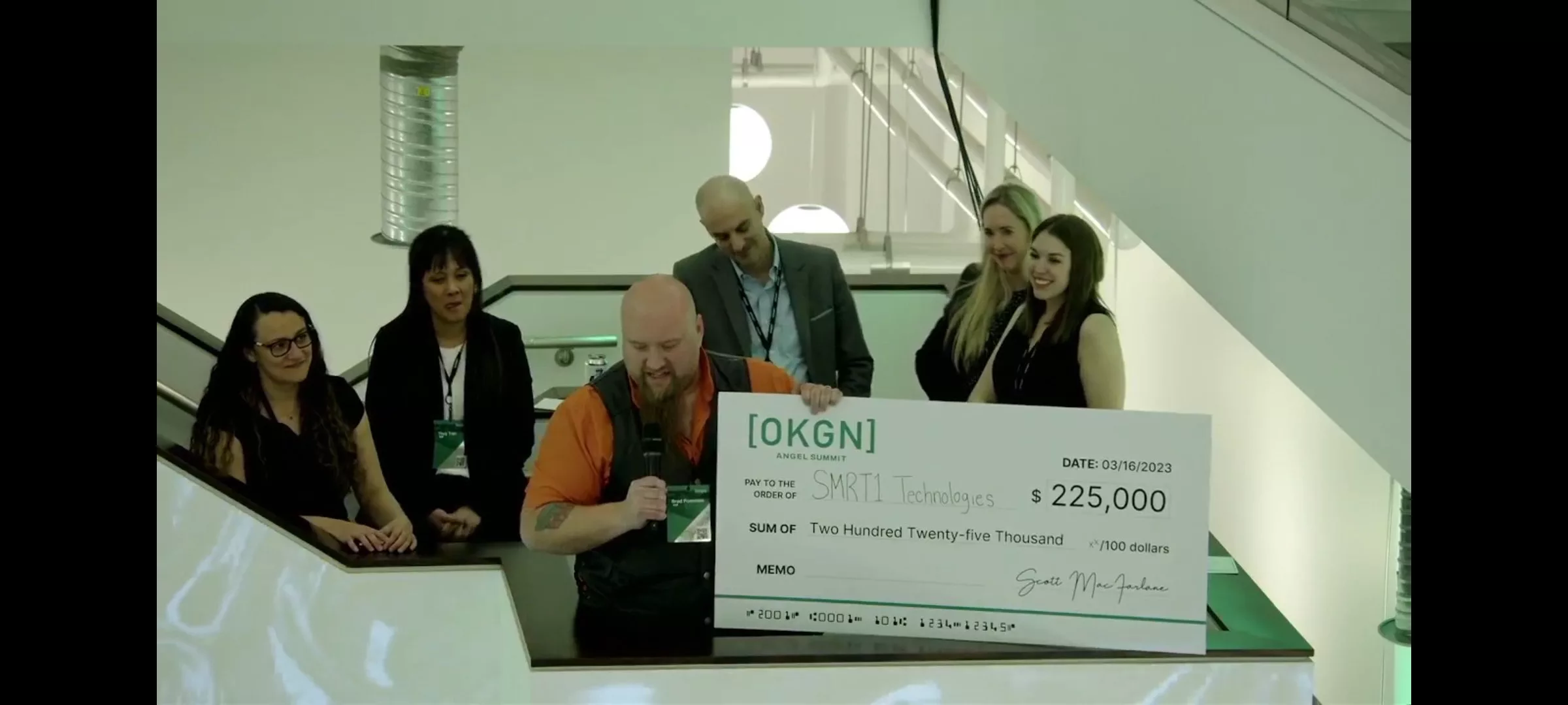 Brad Pommen CEO SMRT1 Technologies holds his $225K investment prize as it's announced SMRT1 has won the top prize at the OKGN Angel Summit 2023